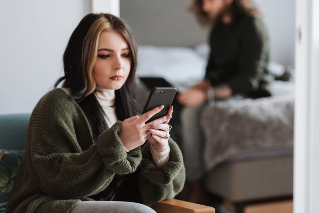 woman sitting using smart phone