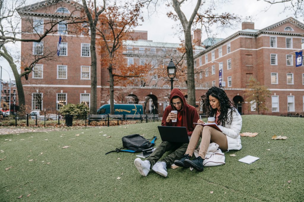 Student ambassador on campus with another student doing homework